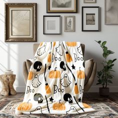 a living room with pictures on the wall and a chair covered in a halloween blanket