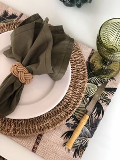 a place setting with green napkins and other items on the table, including a plate