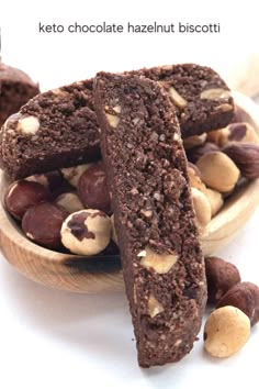 chocolate hazelnut biscotti in a wooden bowl on a white surface with nuts