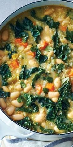 a pot filled with beans, spinach and carrots