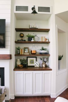 a living room filled with lots of furniture and shelves next to a tv mounted on the wall