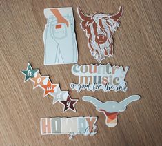 various stickers on a wooden surface with the words country music