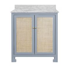 a white sink sitting next to a blue cabinet with wicker doors and a marble top