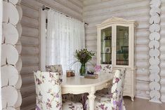 a dining room table and chairs with flowers on them