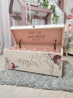 a wooden box with writing on it sitting on a rug in front of a chair