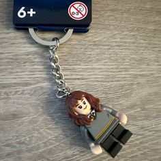 a lego figure keychain is attached to a card case on a wooden table