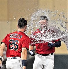 two baseball players splashing water on each other