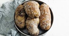 a bowl filled with donuts covered in powdered sugar