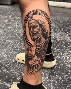 a man's leg with a tattoo on it that has an image of jesus