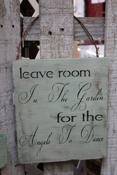 a sign hanging on the side of a wooden fence that says leave room in the garden for the angels to dance