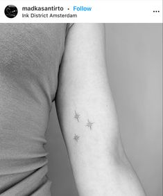 a woman's arm with three small stars on the left side of her arm