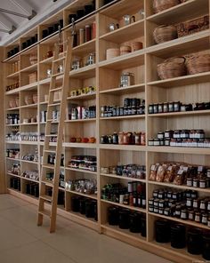 a large wooden shelf filled with lots of shelves and baskets next to a ladder in front of it