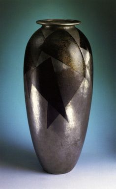 a black and silver vase with a star on the top in front of a blue background