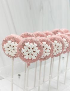 pink and white snowflake cake pops on sticks