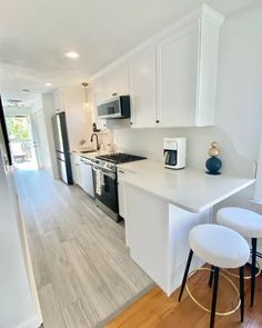 a kitchen with white cabinets and black appliances