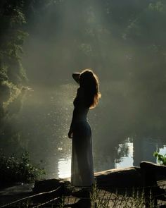 a woman standing in front of a body of water