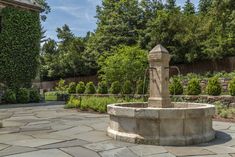 a stone fountain in the middle of a garden