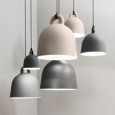 five different colored lamps hanging from the ceiling in a room with white walls and flooring