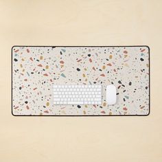 a computer keyboard sitting on top of a white mouse pad covered in confetti