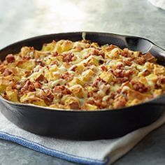 a casserole dish with meat and cheese in it sitting on a blue towel