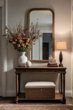 a vase with flowers sitting on top of a wooden table in front of a mirror