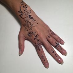 a woman's hand with black ink on it and an intricate design in the middle