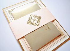 the inside of a wedding card with a gold monogrammed design and an embellishment