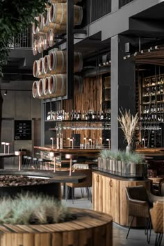 the interior of a restaurant with wooden barrels hanging from the ceiling and tables in front of it