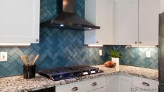 a stove top oven sitting inside of a kitchen next to white cabinets and counter tops