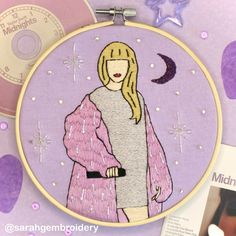 a hand embroidered picture of a woman wearing a pink coat with stars and moon in the background