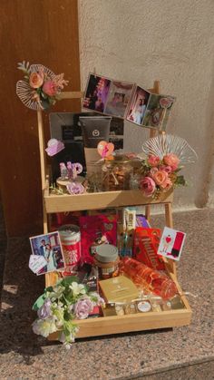 a wooden shelf with pictures and flowers on it