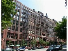 an apartment building with many windows and cars parked on the street