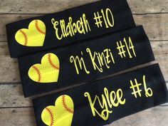 three black softball wristbands with yellow hearts on them