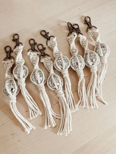 five white tasselled key chains on a wooden table