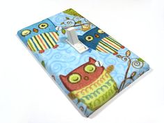 a light switch cover with an owl and owl print on it, sitting on a white surface