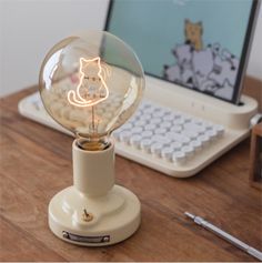 a light bulb sitting on top of a wooden table next to a laptop computer and mouse