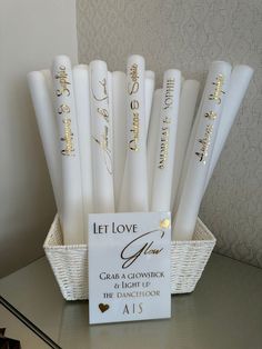 white candles with gold lettering in a basket