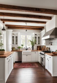 a kitchen with white cabinets and wood floors