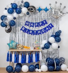 a blue and white birthday party with balloons, streamers, tassels and decorations