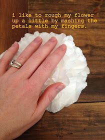 a woman's hand on top of a paper towel with the words i like to rough my flowers up a little by mashing the petals with my fingers