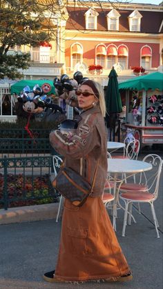 a woman is walking down the street with her hand on her hip and holding a purse