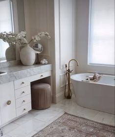 a bath room with a tub a sink and a large mirror on the wall above it