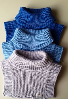 four knitted sweaters are lined up together