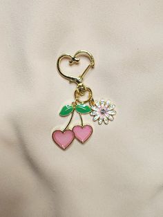 a keychain with two hearts and a flower attached to it's side