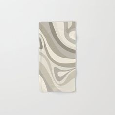 a white towel with grey and beige swirls on it's side, hanging from a wall