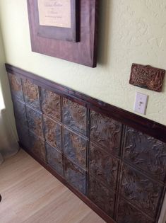 a wooden headboard in the corner of a room next to a wall with pictures on it