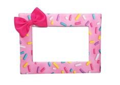 a pink frame decorated with sprinkles and a bow