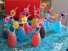 there are many small vases with flowers in them on the blue tableclothed cloth