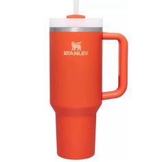 an orange travel mug with a straw sticking out of the lid and handle, on a white background