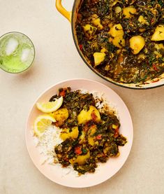 a plate of food next to a bowl of rice and a glass of green tea